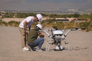 With the Las Vegas strip visible in the distance, a pair of technicians from South Korean conglomerate Doosan perform a final check on their aircraft prior to conducting a demonstration flight at the Commercial UAV Expo’s outdoor event.